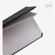 Load image into Gallery viewer, Franklin-Christoph A6 ruled journal with black Firma-Flex cover and lavender-hued paper. Features debossed logo and beveled corners.