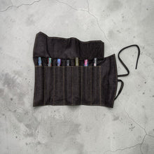 Load image into Gallery viewer, Franklin-Christoph dark denim fabric seven pen roll with tie closure, holding colorful pens.