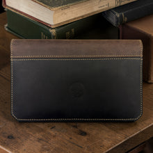 Load image into Gallery viewer, Franklin-Christoph two-tone boot leather checkbook cover in black and brown, featuring a Celtic knot emblem.